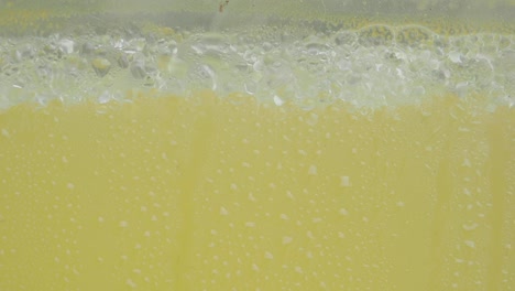 close up of condensation on a yellow liquid in a glass container