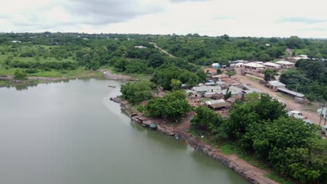 orbiting aerial shot of small fishing village by lake in ghana west africa