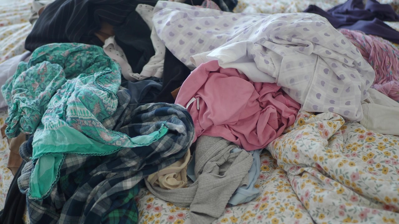Messy Pile of Assorted Clothing on a Bed