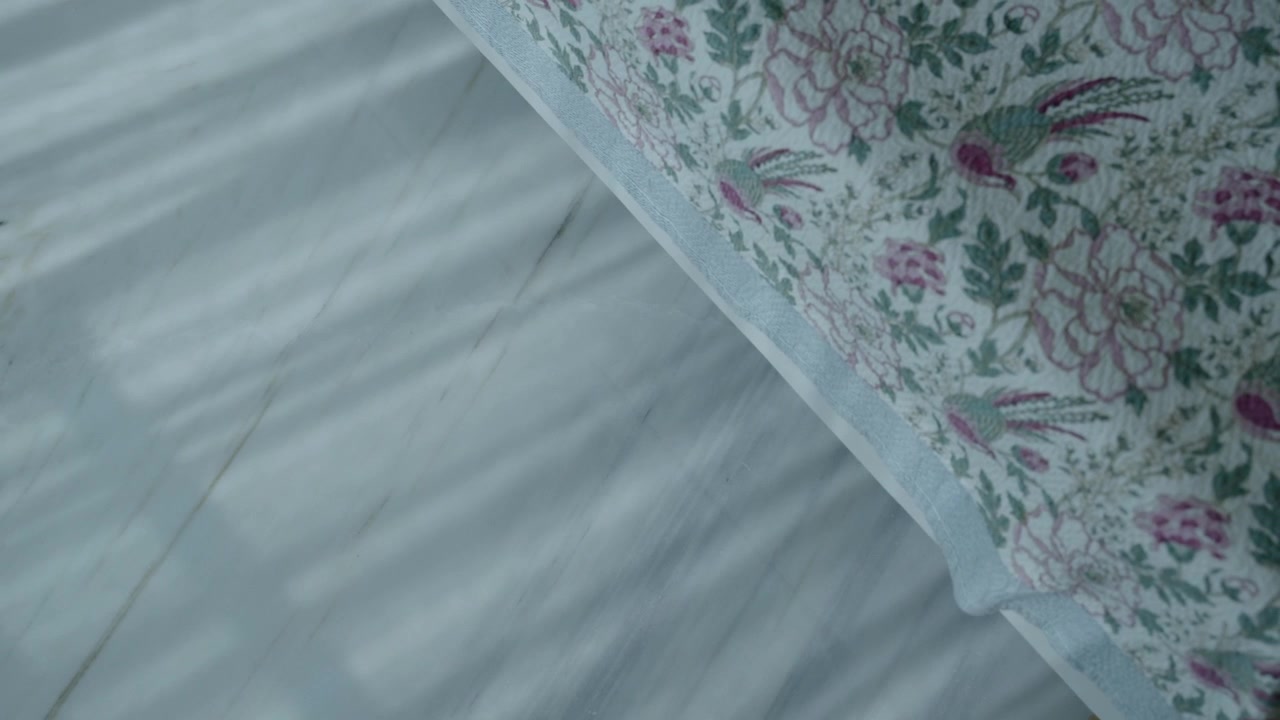 Ombra di una tenda sul pavimento con tovaglia floreale