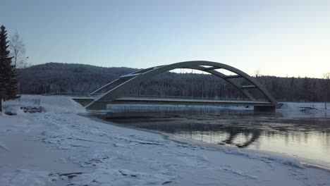 A-bridge-in-a-rural-frozen-landscape-of-Sweden,-during-winter