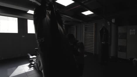 young athletic man doing exercise at the gym with a punching bag