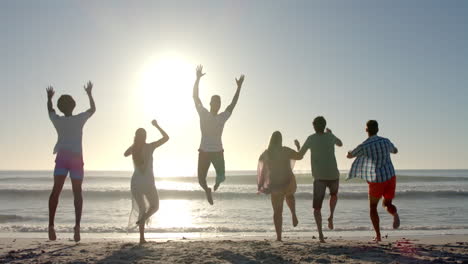 Verschiedene-Freunde-Springen-Freudig-An-Einem-Sonnigen-Strand