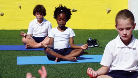 yoga instructor instructing children in performing yoga