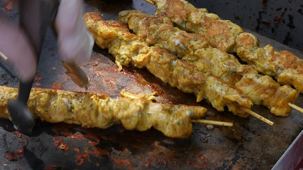Lähikuva marinoiduista lihavartaista (maurilaiset kebabit) kuumalla, rasvaisella paistopinnalla