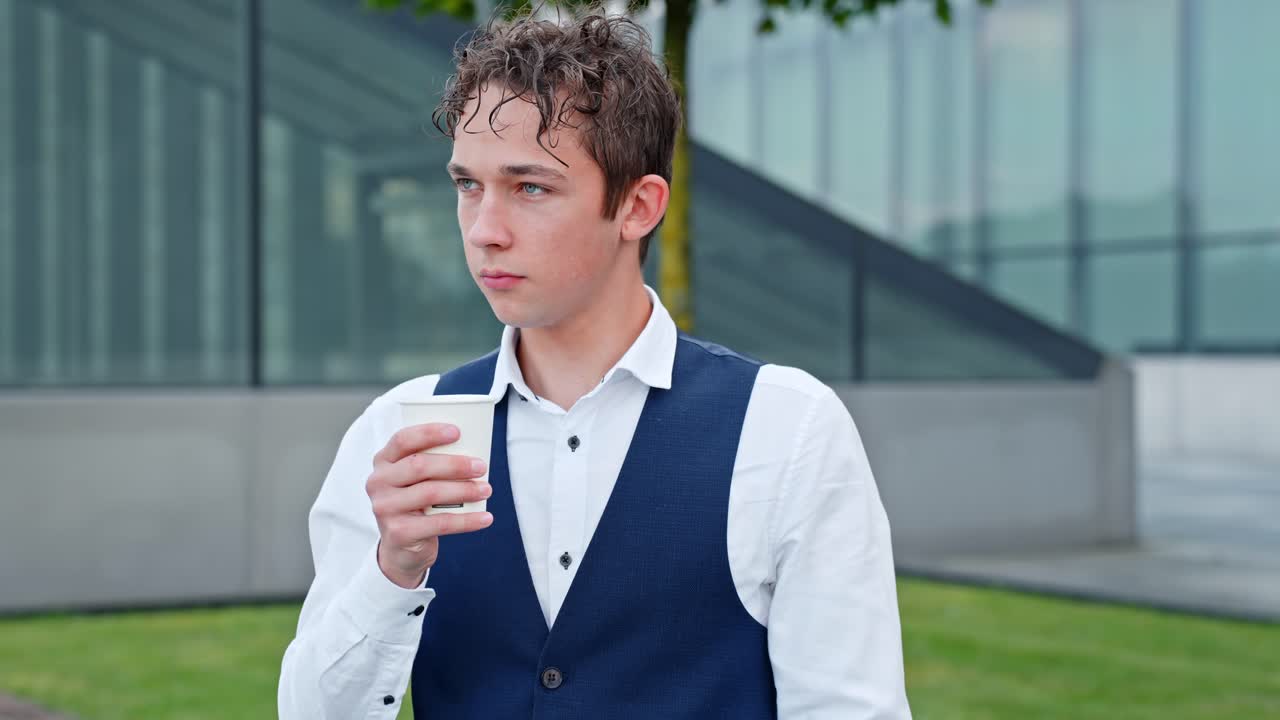 Young Businessman Blowing His Cup Of Coffee Before Drinking During His Breaktime. - closeup shot