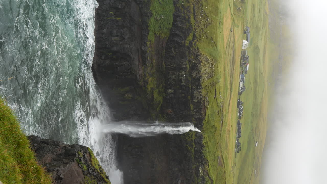 Vertical - Mulafossur Waterfall And Misty Village Of Gasadalur On Vagar Island, Faroe Islands. static shot