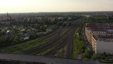 Luftaufnahme-Der-Mehrspurigen-Eisenbahnlinie-In-Der-Stadt.-über-Wohngebäude-Fliegen.-Panoramablick-Auf-Die-Großstadt-In-Der-Späten-Abendsonne.-Berlin,-Deutschland