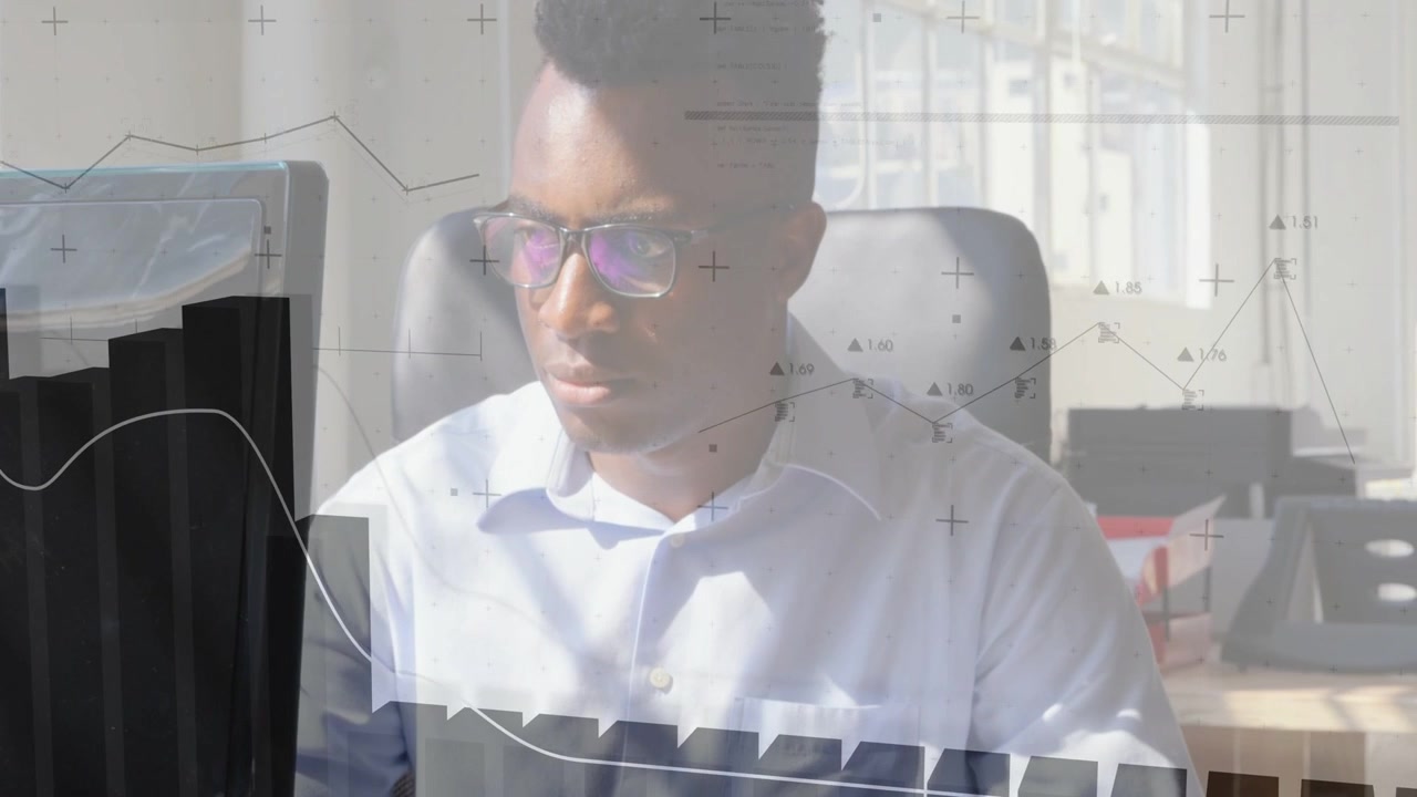 Male analyst typing, pausing, raising gaze to monitor, studying charts over torso for data insight