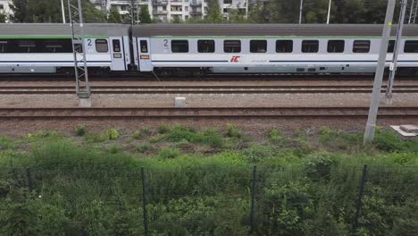 Dos-Trenes-Que-Se-Cruzan-Mirando-Hacia-Abajo-Desde-Un-Dron-En-Cracovia,-Polonia