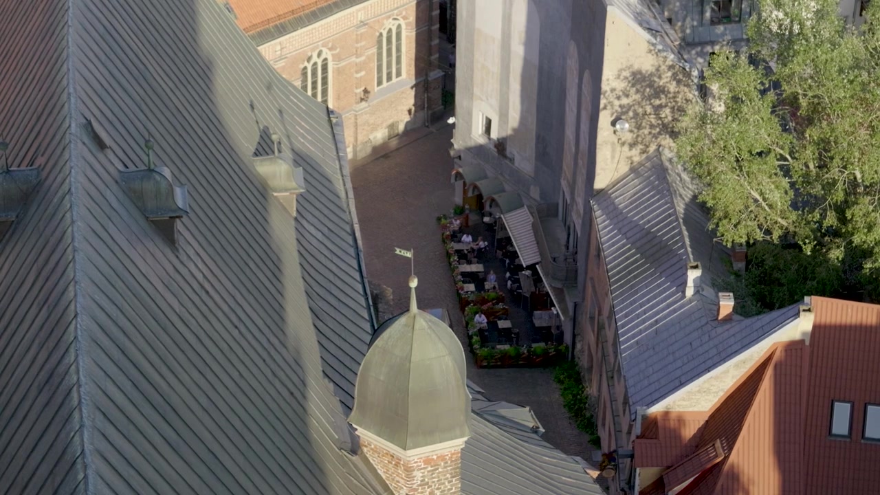 People enjoying outdoor seats in typical European small city cafe, above view