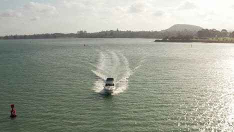 barco de pesca navegando rápidamente en mar abierto y acercándose al puerto, tiro aéreo