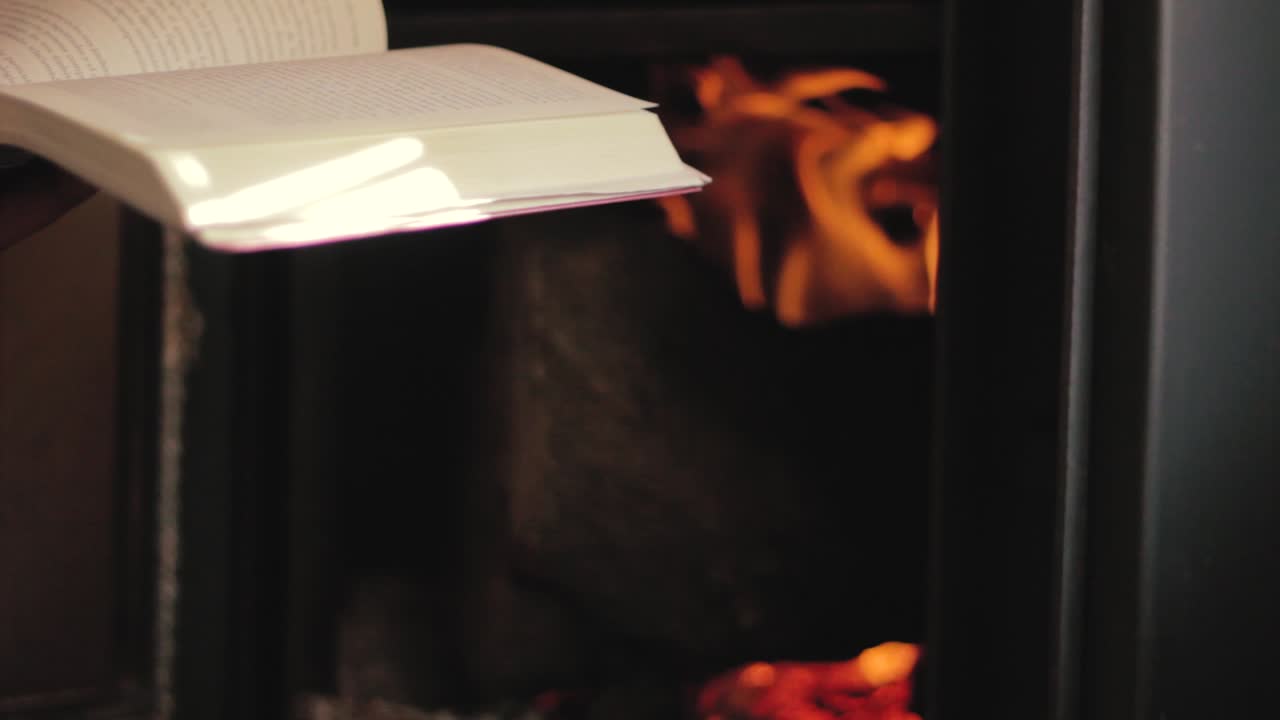 난로 앞에서 책을 읽는 남자