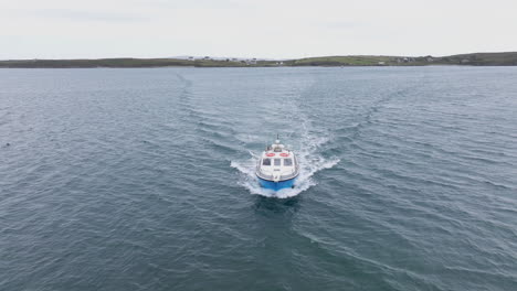 small motorboat sailing on calm waters near an island