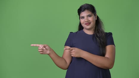 joven sobrepeso hermosa mujer de negocios india contra fondo verde