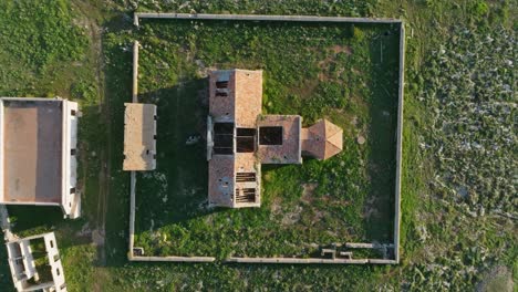 Drone-De-Arriba-Hacia-Abajo-Elevándose-Sobre-Un-Antiguo-Edificio-En-Ruinas-Con-Paredes-De-Ladrillo-En-Sa-Falconera-Madeira