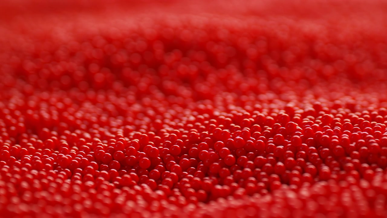 Closeup Red Bead Field Reveals Texture. Intimate Studio Macro Of Thousands Of Tiny Spherical Beads In Soft