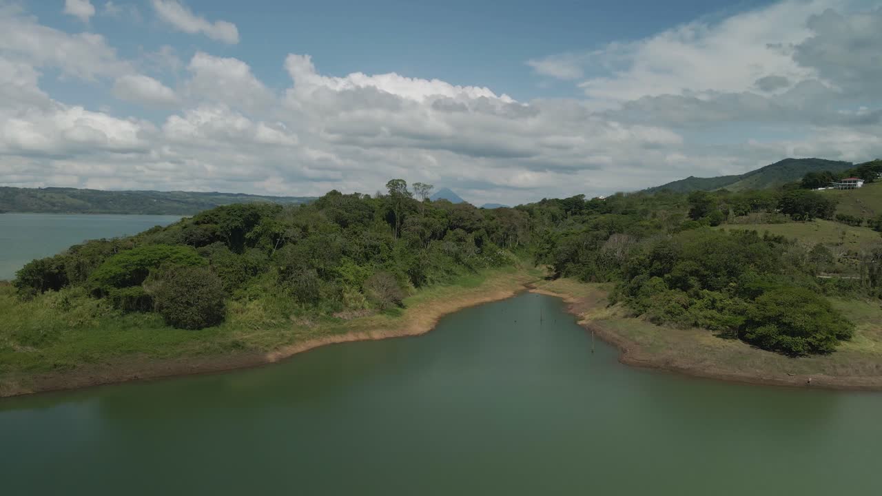 hermosa toma aérea cinematográfica de la laguna de arenal con el volcán de arenal en el fondo