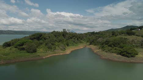 Wunderschöne-Filmische-Luftaufnahme-Der-Arenal-Lagune-Mit-Dem-Arenal-Vulkan-Im-Hintergrund