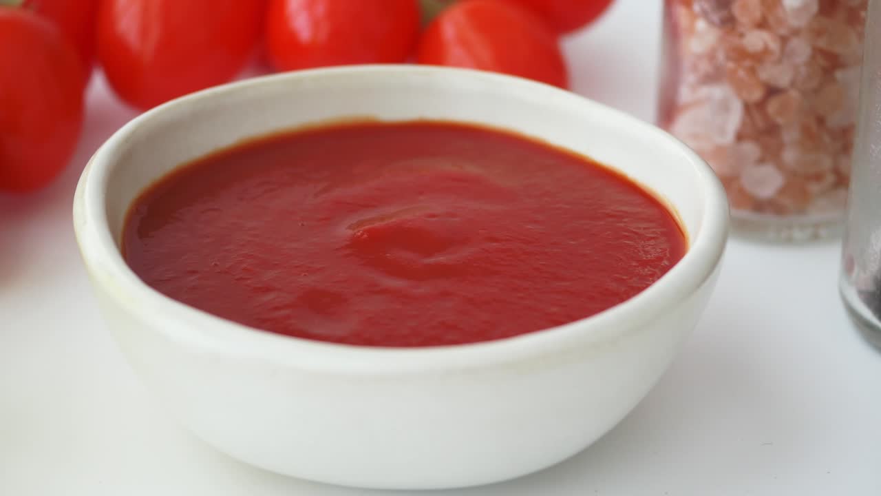 Ciotola di salsa di pomodoro rossa con pomodori freschi e spezie