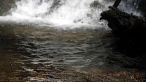 cámara lenta de agua que fluye en primer plano con cascada furiosa en segundo plano a 180 fps