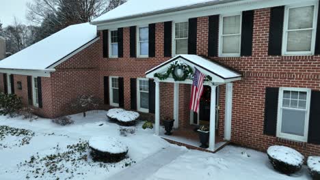 large suburban brick home with american flag