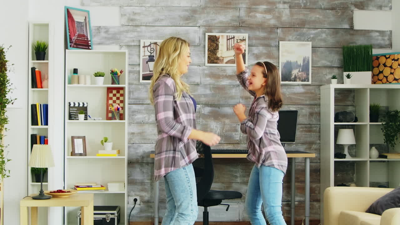 아름다운 젊은 어머니가 방에서 그녀와 함께 춤을 춘다