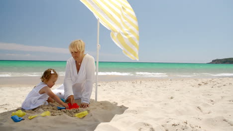 Niña-Jugando-En-La-Arena-De-La-Playa-Con-Mamá