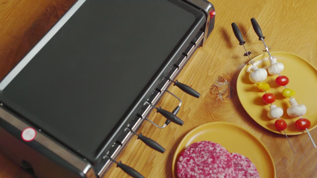 Vegetable skewers loaded into plancha grill. Static topdown shot