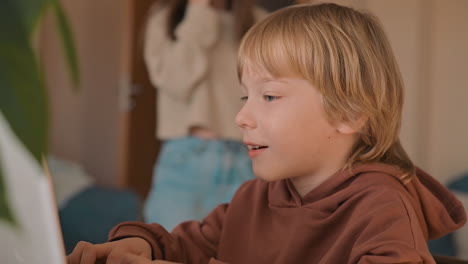 niño pequeño y hermana mayor usando una computadora portátil y un teléfono inteligente en casa