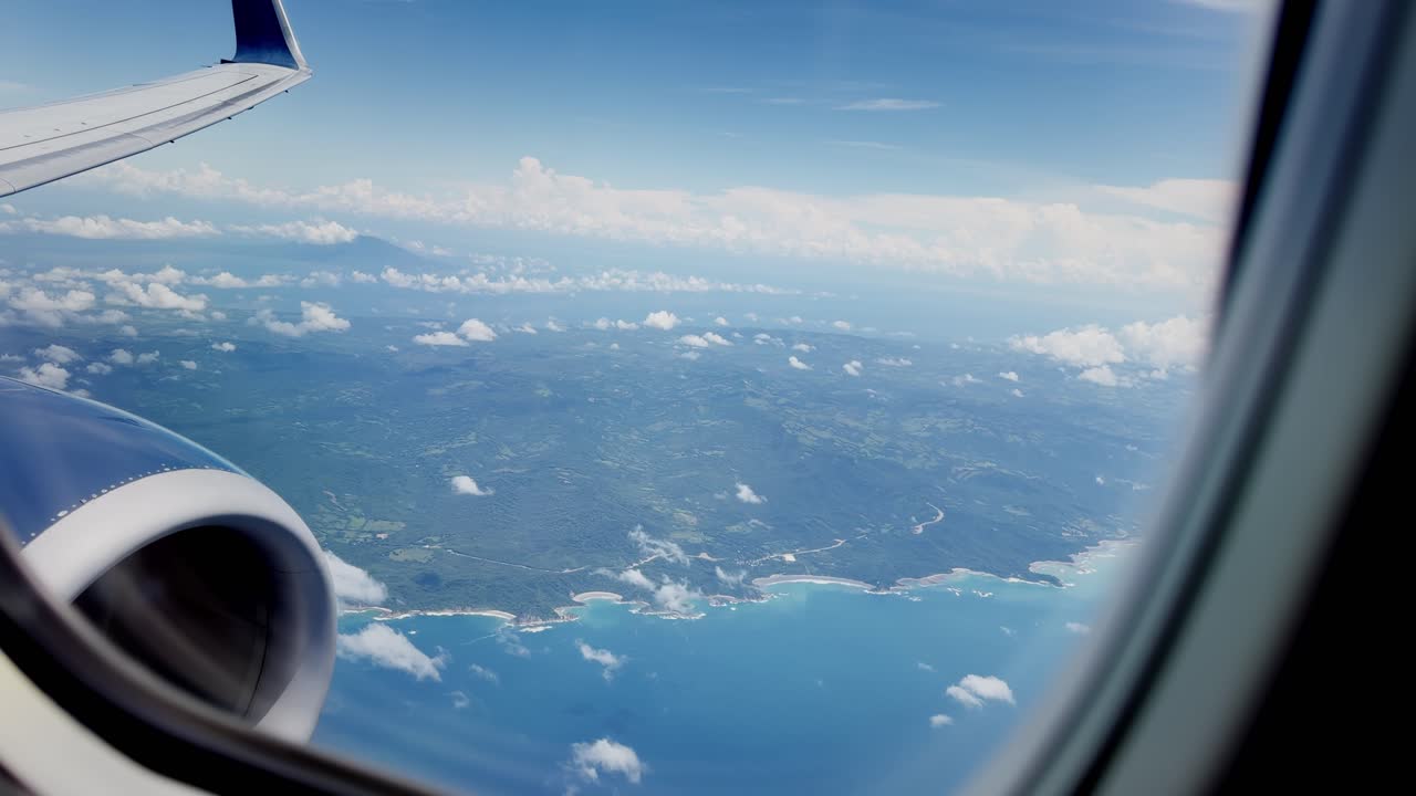 View of Nicaragua and ocean from commercial flight showing wing