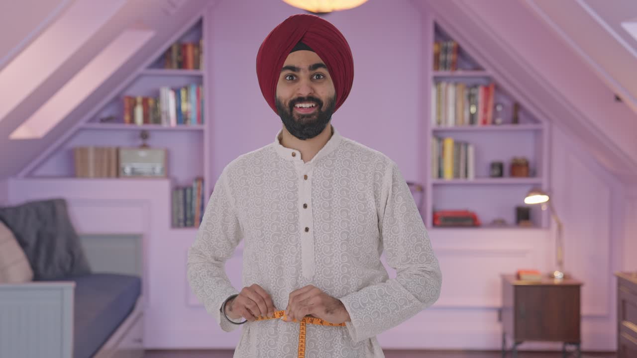 hombre indio sikh feliz midiendo la cintura usando cinta de pulgada