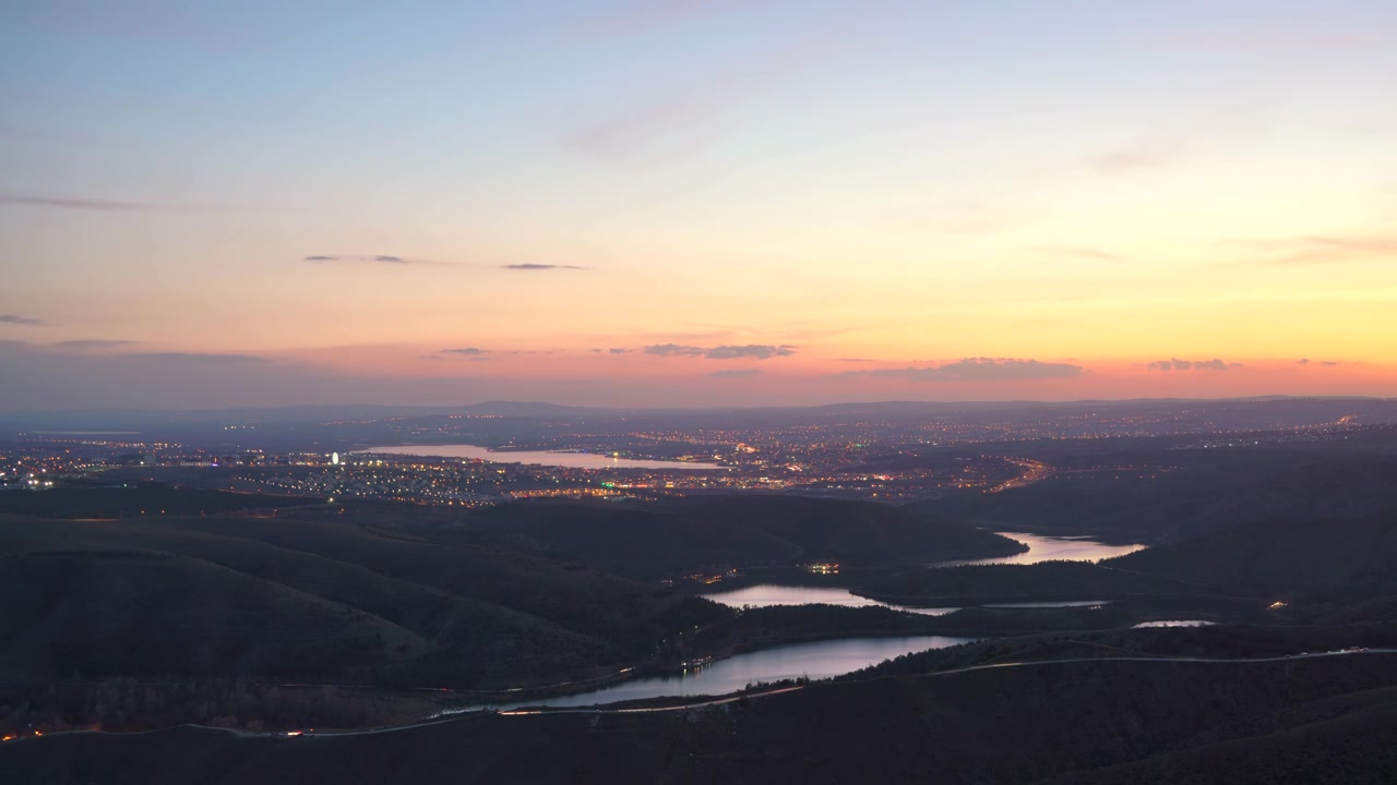 Time Lapse of City Lights at Sunset Overlooking a Reservoir