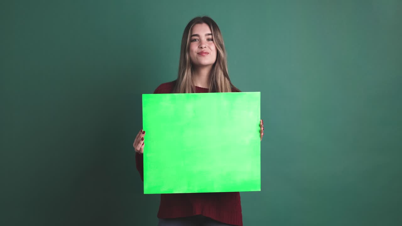 Woman holding a panel and then smiling