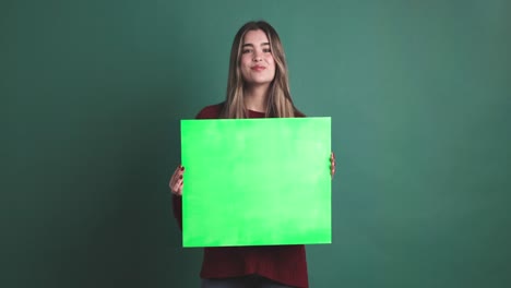 woman holding a panel and then smiling