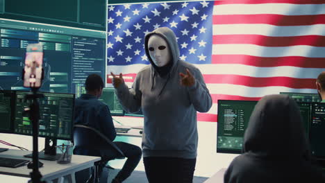 persona con máscara anónima trabajando en inteligencia en una sala de hacking gubernamental