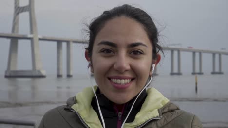 happy hindu woman with earphones looking at camera