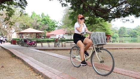 cyclists riding past horse-drawn carriages in a park