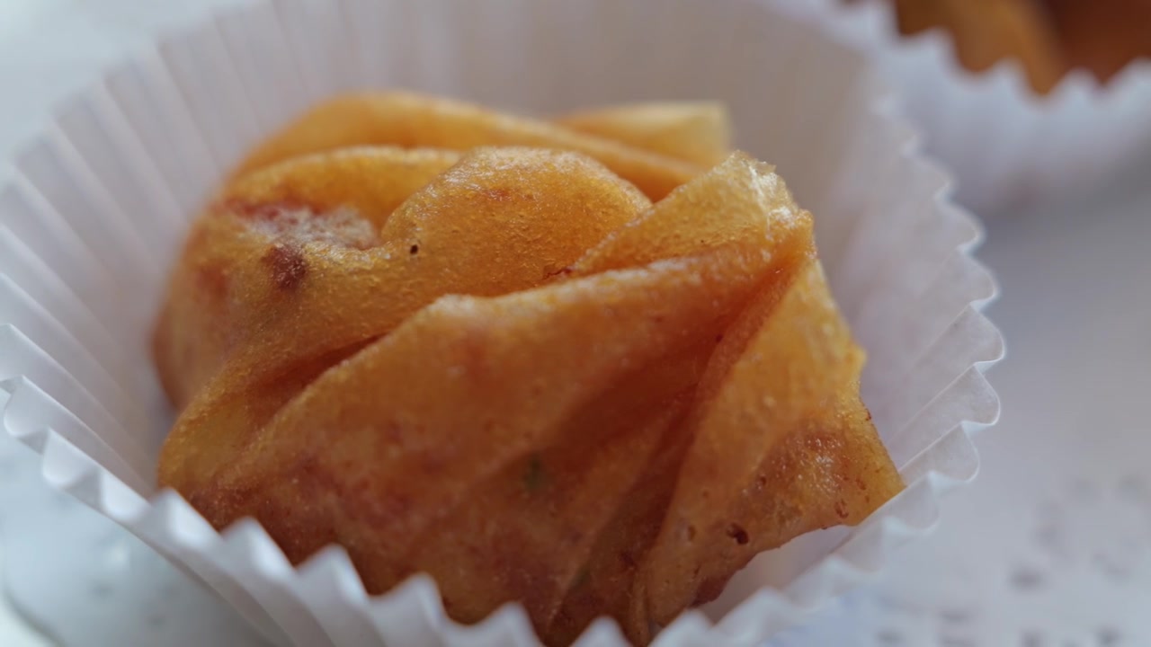 Primo piano di polpette di pesce tailandesi appena fritte con una superficie dorata e croccante, servite su un piatto come antipasto tradizionale tailandese salato