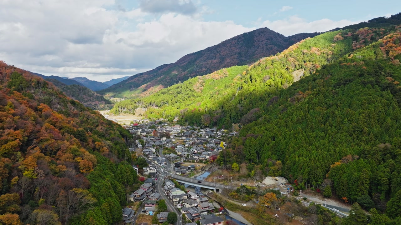 Aerial drone establishing fly Kyoto City Japan landscape in Autumn, town Valley between mountains and skyline