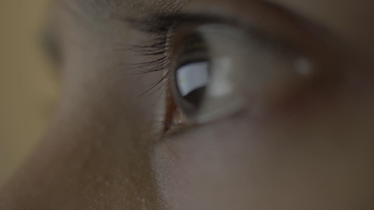 웹에서 둠스크롤링이나 둠서핑을 하는 동안 데스크탑 화면을 반사하는 여성의 눈을 매우 극단적으로 클로즈업하여 눈에 건강에 해로운 부담을 줍니다.