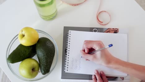 Plano-De-Cerca,-La-Chica-Flaca-Escribe-Una-Dieta-Para-Su-Dieta.