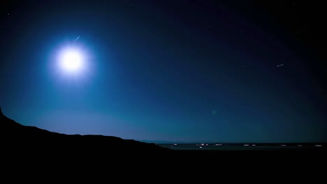 lapso de tiempo de la luna saliendo por encima de una carretera distante en el desierto por la noche