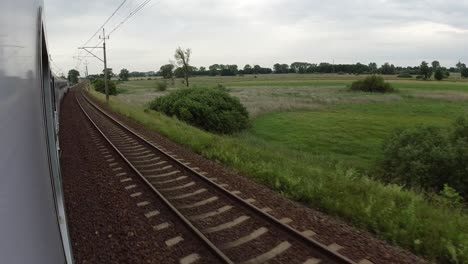 Una-Vista-De-Las-Vías-Del-Tren-Y-Los-Campos-Desde-Un-Tren-En-Movimiento-Rápido