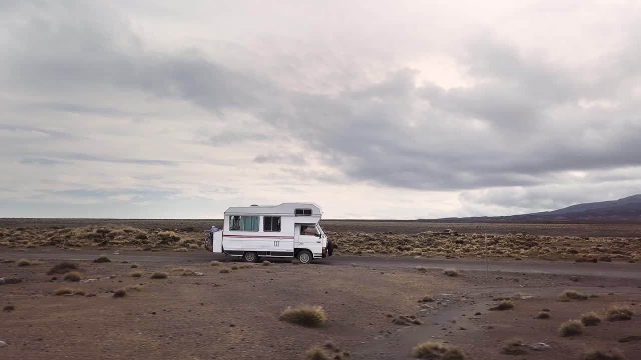Couple on a road trip in a camper van through a desert landscape