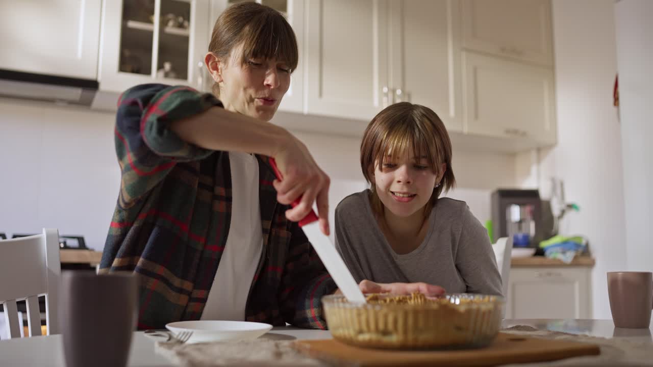 Mother and Daughter Cutting Pie in Kitchen