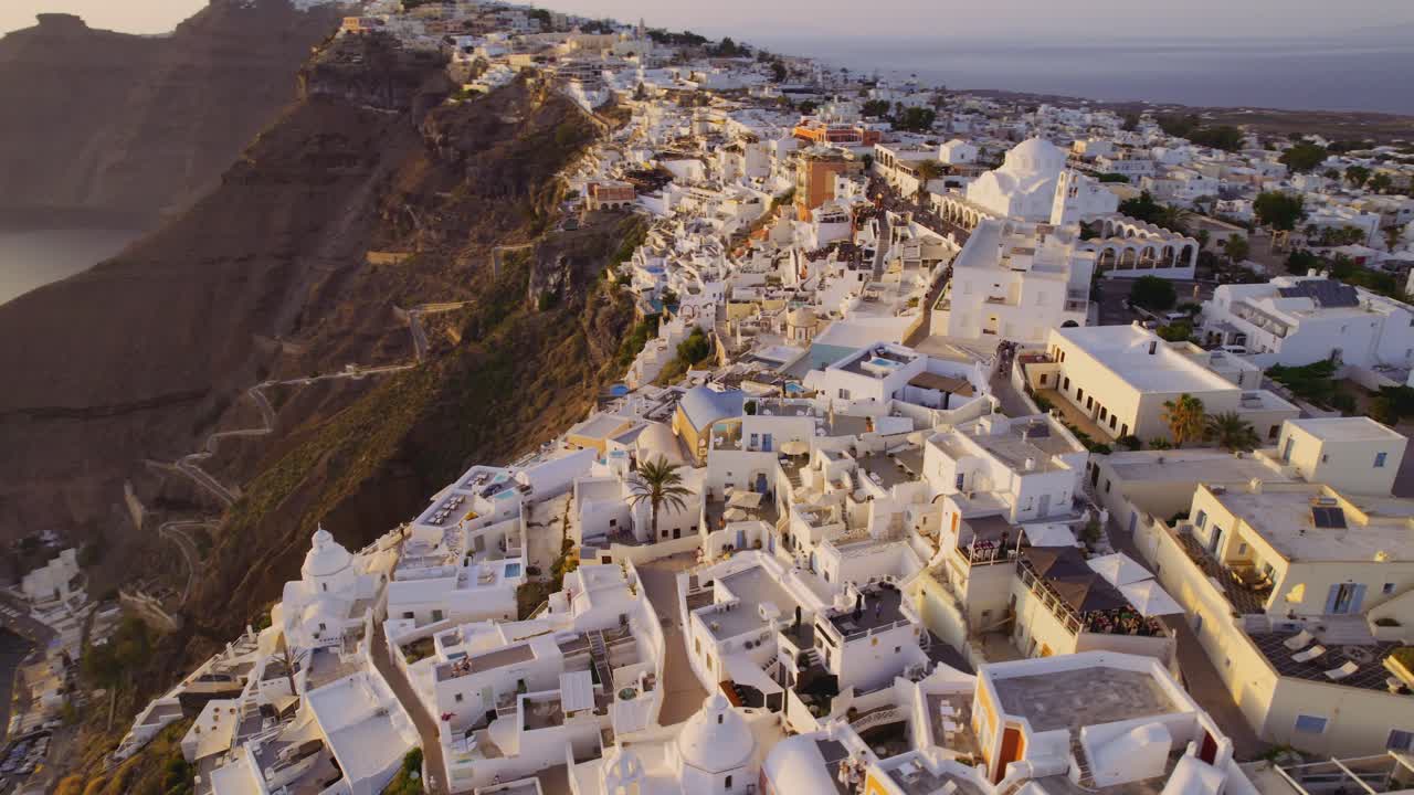 Aerial views of the picturesque white-washed town of Santorini on a cliff overlooking the Aegean Sea