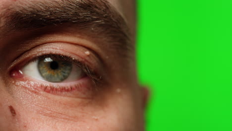 close-up of a man's eye on a green screen