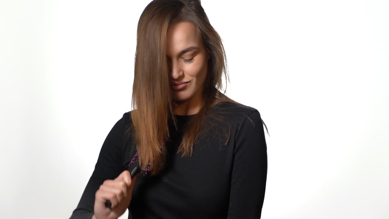 Pathos woman brushing her hair. Pretty beautiful charming woman with pathos view brushing hair, isolated on white background