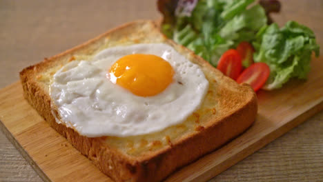 homemade bread toasted with cheese and fried egg on top with vegetable salad for breakfast